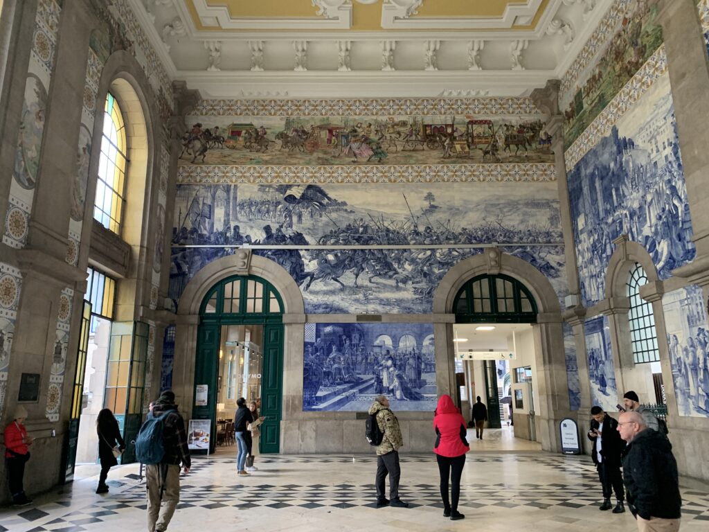 Depiction in painted tiles of the Battle of Valdevez (top) and the arrival of Egas Moniz and his children at the court of Alfonso VII, king of León and Castile, at the São Bento train station in Porto.